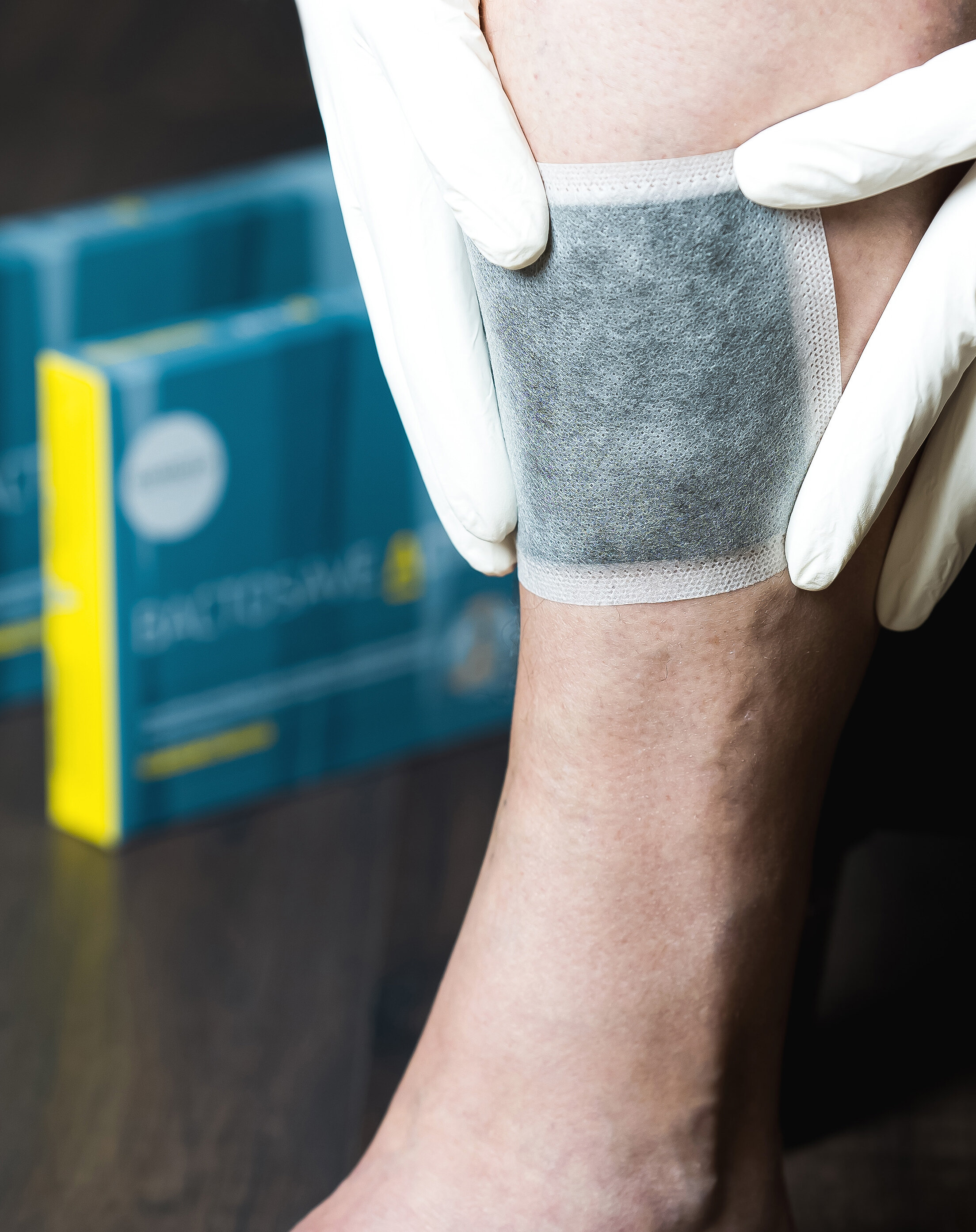 Die zwei Verpackungsgrößen von BactoSave Active® stehend auf einem dunklen Holzboden. | © Bamboo Health Care GmbH